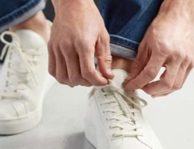 homme portant des baskets blanches