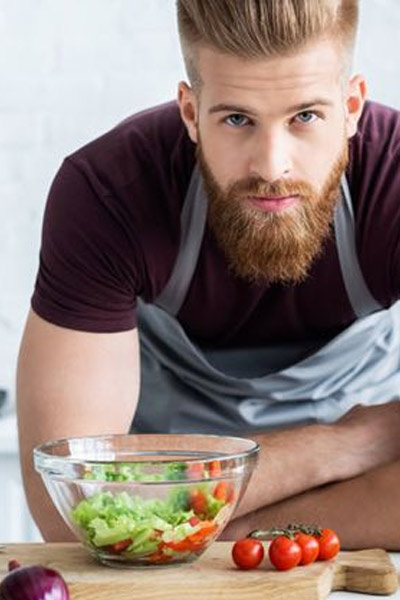 homme mangeant des légumes pour favoriser la pousse de la barbe