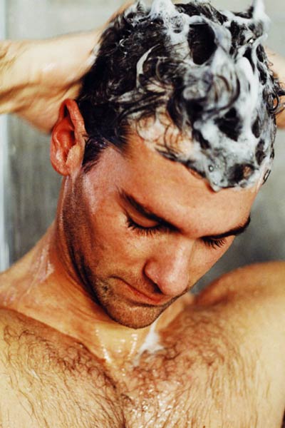 homme se faisant un shampoing antipelliculaire
